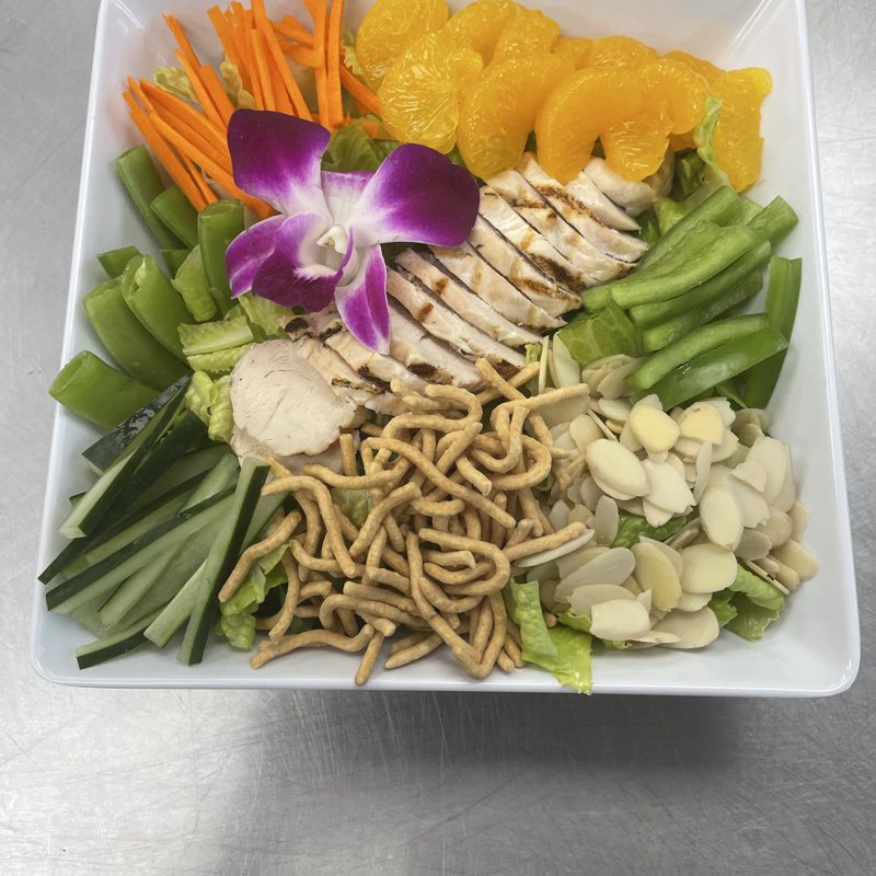 Grilled chicken Asian salad with mandarin, almonds and crispy noodles